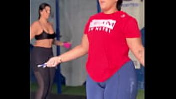 At the gym, a plump female is jumping rope.