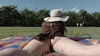 enjoying a leisurely meal in a park while nude. exposing one's pussy and breasts in public.