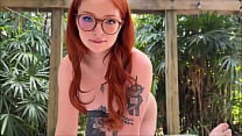 Gorgeous, naive girl with tattoos and spectacles who is infatuated